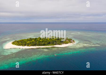 Isola tropicale con spiaggia bianca e foresta. Seascape, isole filippine.Una piccola isola circondata da acque azzurre e barriere coralline, una vista dall'alto. Foto Stock