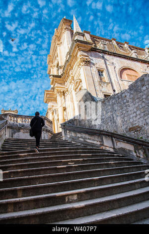 Donna che cammina su per le scale fino alla Cattedrale di Dubrovnik Foto Stock