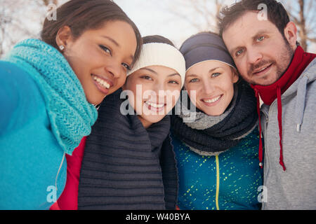 Gruppo di amici gustando nella neve in inverno Foto Stock