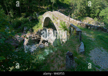 Bella romano antico ponte in pietra che si trova su un percorso di trekking vicino a Bignasco village nella bellissima Valle Maggia in Ticino, Svizzera Foto Stock