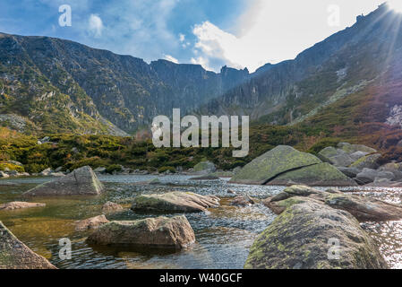 Sole brillante raggi nel drammatico paesaggio di montagna con laghi e scogliere, Snowy Box, Karkonosze, Polonia Foto Stock