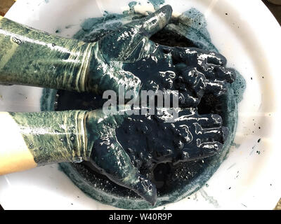 La mano sulla torta di indigo . Bellezza naturale intendono sfondo . Concetto di colorante di natura Foto Stock