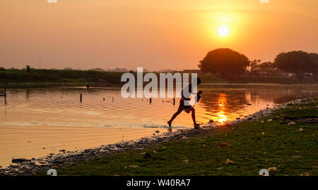 Mandalay, Myanmar - Feb 20, 2016. Un uomo locale per la cattura di pesce sul lago al tramonto a Mandalay, Myanmar (Birmania). Foto Stock