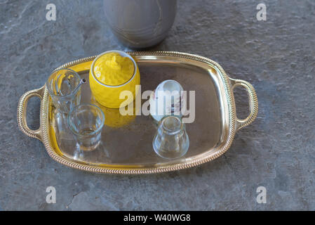 Dopo essere partito. Un vassoio vuoto e sporco tazza da caffè, tè sporco vetro, Sugar Bowl, teiera, cucchiaio in una tenda beduina sul pavimento. Foto Stock