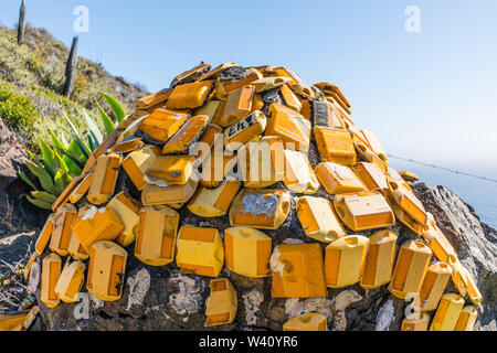 Una scultura creativa fatta di arancione e giallo riflettente autostrada marcatori posti sul lato dell'autostrada 1 costa centrale della California vicino al Grande S Foto Stock