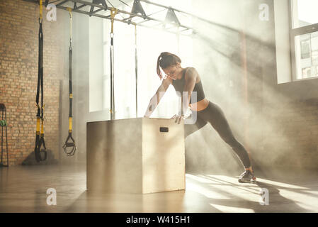 Lo sport professionistico. Giovane bella donna atletica in sportswear facendo push-up presso la palestra. Lo sport professionistico. Allenamento Foto Stock