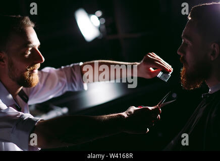 Fiducioso uomo visitando un parrucchiere in un barbiere. Foto Stock