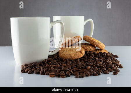 Caffè e biscotti. Il tempo per rilassarsi. Coppe di bianco con caffè e semi tostati. Foto Stock