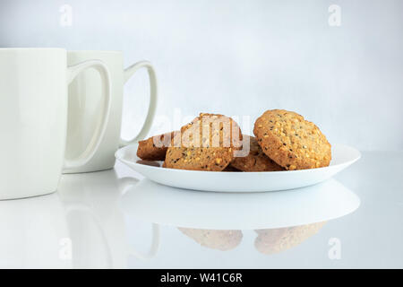Caffè e biscotti. Il tempo per rilassarsi. Coppe di bianco con caffè e semi tostati. Foto Stock