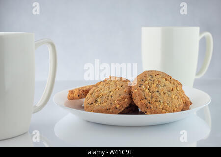 Caffè e biscotti. Il tempo per rilassarsi. Coppe di bianco con caffè e semi tostati. Foto Stock