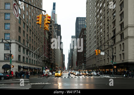 Guardando verso il basso sesto (6°) avenue e da Central Park in durante un nitido e inverni umidi giorno nel Centro Cittadino di New York City, New York, Stati Uniti d'America Foto Stock