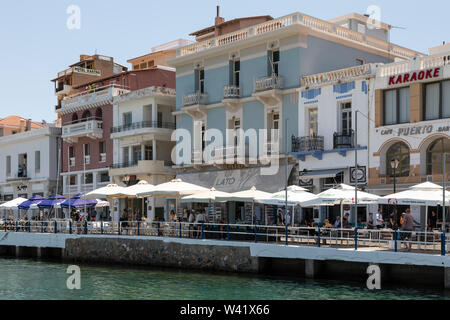 Di vivaci ristoranti e bar e caffetterie lungo la passeggiata lungomare in Agios Nikolaos, Creta, Grecia Foto Stock