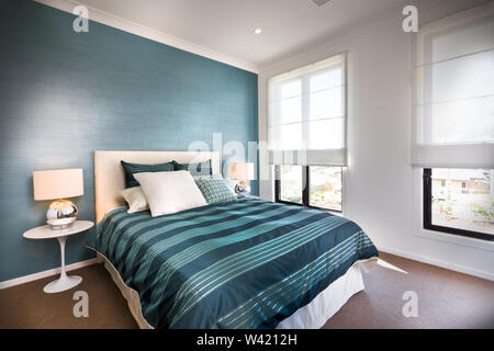 Close up di un blu camera da letto decorativo con pareti bianche, compresa una finestra vicino i cuscini e le spie luminose sul pavimento moquette, la tenda lo streaming dei s Foto Stock