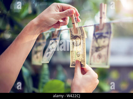 US dollar banconote appeso alla fune per il riciclaggio di denaro sporco mano conept raccogliere soldi Foto Stock