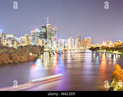 Paesaggio notturno panorama e il cielo blu scuro con una foresta di illuminazione luci luminose dietro un fiume e riflessi colorati a Brisbane, Queensland, Austr Foto Stock