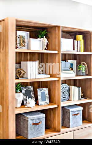 Vecchio scaffale di legno con fantasia e oggetti di antiquariato come vecchie scatole e libri accanto a cornici e smussi in legno accanto a vasi e 3d elementi come statue Foto Stock