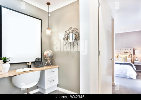 Moderna area di studio fissata per la camera da letto in una casa di lusso tra cui specchio di fantasia accanto a 3d lettera e del mondo Foto Stock