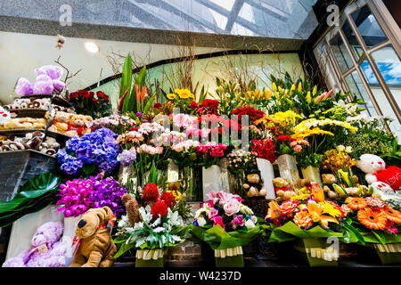 Chiudere su di un fiore regali con mazzi di fiori e orsacchiotti nelle caselle a prendere e poco farcite i cani in un moderno showroom Foto Stock