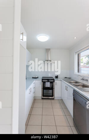 Una vista di una lussuosa zona cucina dotata di forno, camino, pulire i contatori e dissipatore di grandi dimensioni Foto Stock