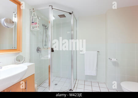 Uno stile moderno bagno con una doccia walk-in, un asciugamano appendiabiti e un lavabo con cabinet Foto Stock