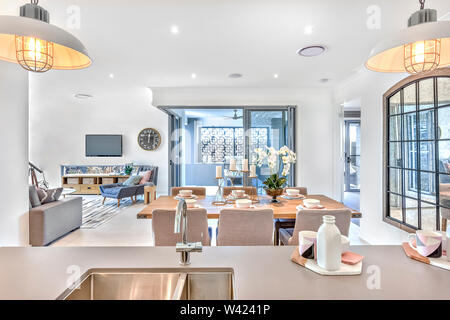 Sala da pranzo moderna cucina con bancone e soggiorno nel centro della casa Foto Stock