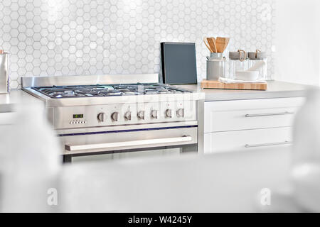 Moderna stufa a gas vista superiore con utensili da cucina accanto a forma di ape tile parete, anteriore è sfocata e concentrarsi sul retro, molto pulito anche una zona perfetta lightnin Foto Stock