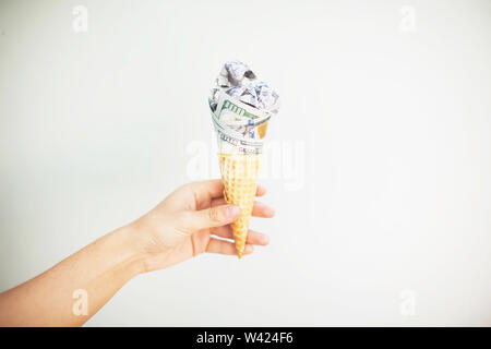 Wafer monetaria. le fatture del dollaro arrotolato nel cono gelato Foto Stock