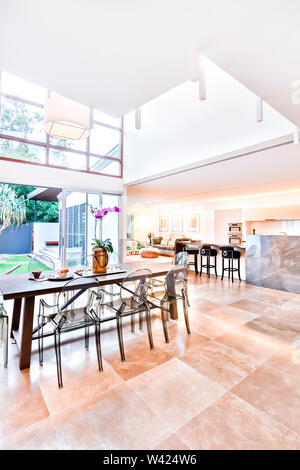 Casa indoor e outdoor compresi cena o sul patio sul pavimento di piastrelle, l'esterno può essere visto attraverso il vetro di porta e finestra, la zona pranzo Foto Stock