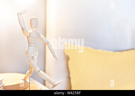 Legno bambola di osso da vicino con una camera da letto sfocata sfondo, dando una danza pongono usando un sostenitore sotto la luce della lampada di illuminazione di una casa moderna Foto Stock