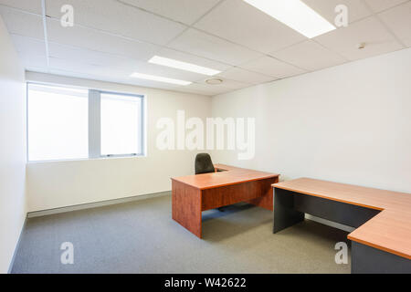 Ufficio elegante cabina minimalista con finitura in legno Mobili, finestre scorrevoli e rettangolare luci a soffitto. Foto Stock