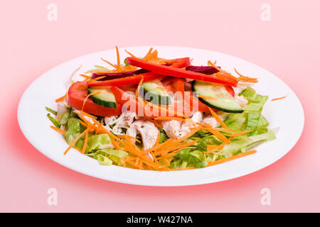 Deliziosa insalatiera con la proteina, burger caldo con carne e verdure, molto gustosa guardare, lo sfondo è di colore rosa, tavolo da pranzo di un hotel di lusso Foto Stock