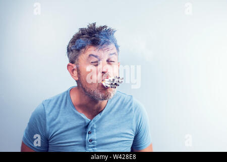 Chiusura del portacenere pieno di sigarette, con l'uomo nel lavoro in  background sul computer portatile e fumare in luoghi chiusi su la mattina  presto Foto stock - Alamy