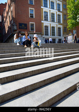 Londra, Inghilterra, Regno Unito. Giovani donne giapponesi seduti sui gradini su Pietro Hill, vicino la Cattedrale di St Paul Foto Stock