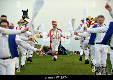 Morris Dancing sulla sommità di Painswick Beacon per celebrare sunrise il giorno di maggio Foto Stock