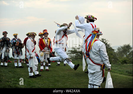 Morris Dancing sulla sommità di Painswick Beacon per celebrare sunrise il giorno di maggio Foto Stock