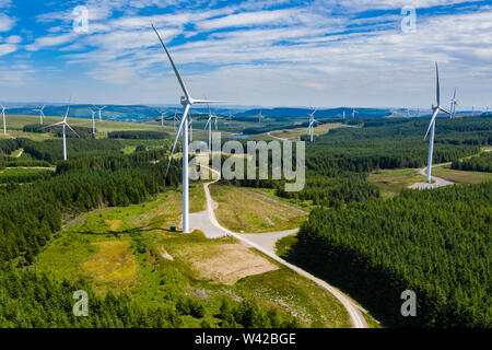 Antenna vista drone di turbine a grandi centrali eoliche onshore su una verde collina (Pen y Cymoedd, Galles) Foto Stock