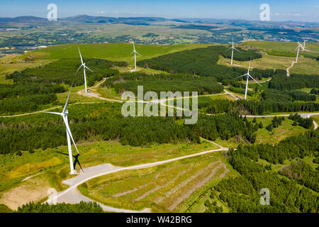 Antenna vista drone di grandi centrali eoliche onshore su una verde collina Foto Stock