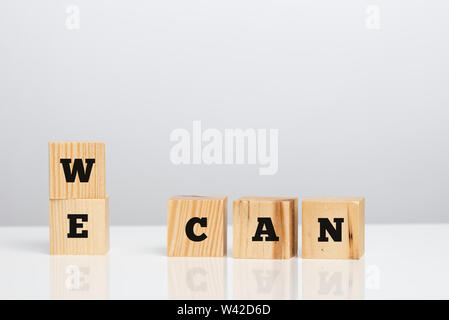 Possiamo messaggio su blocchi di legno , su uno sfondo grigio con copyspace. Foto Stock