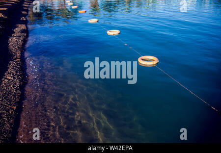 Boe protettivo sulla superficie del mare. La scherma sull'acqua. Salvare la zona per il nuoto Foto Stock