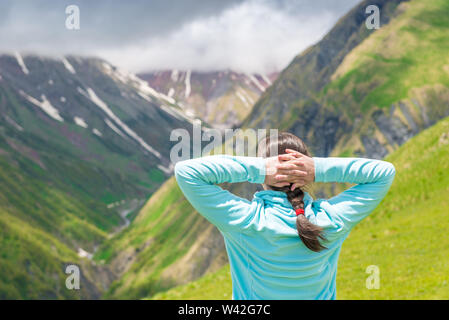 La donna si ammira lo splendido paesaggio di montagna, vista dal retro Foto Stock