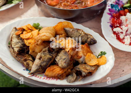 Diversi tipi di pesce in piastre sul tavolo Foto Stock