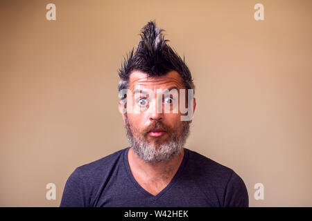 Surptised uomo barbuto con iroquois. Le persone e il concetto di emozione Foto Stock