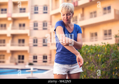 La donna si sente dolore nel gomito. La gente, la sanità e la medicina concept Foto Stock