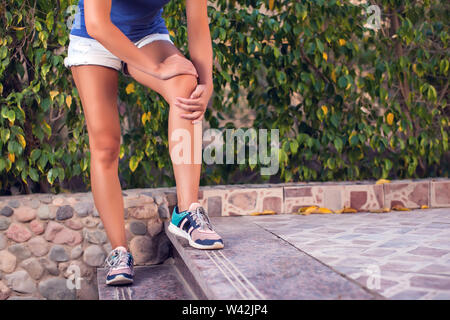 La donna si sente dolore al ginocchio mentre facendo esercizi. Persone, sport, la sanità e la medicina concept Foto Stock