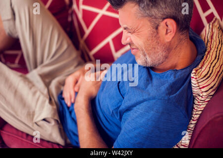 L'uomo sente forte dolore allo stomaco a casa. La gente, la sanità e la medicina concept Foto Stock