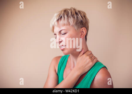 Donna con capelli corti si senta forte dolore al collo isolato. La gente, la sanità e la medicina concept Foto Stock
