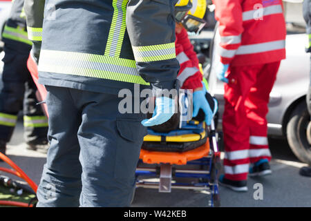 Paramedici e vigili del fuoco in un'operazione di soccorso dopo incidente stradale Foto Stock