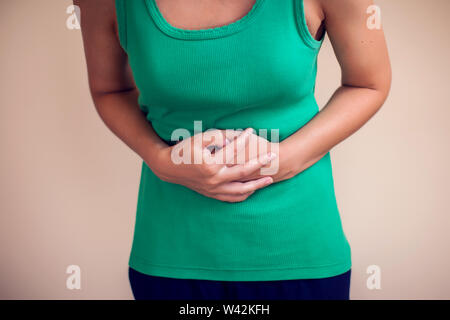 Donna con capelli corti si senta forte dolore allo stomaco isolato. La gente, la sanità e la medicina concept Foto Stock