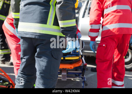 Paramedici e vigili del fuoco in un'operazione di soccorso dopo incidente stradale Foto Stock