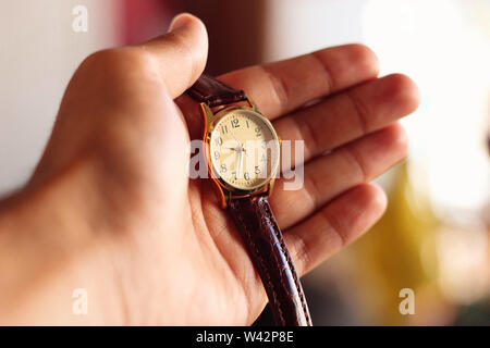 Mano che tiene un orologio al quarzo. Foto Stock